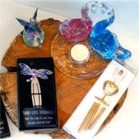 A selection of gift products such as some decorative bookmarks, fairy decorations, a wind chime, and a swan candlestand