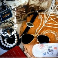 Pearl necklaces, sun glasses, a watch, a glass case, a clock, a picture, and other decorations