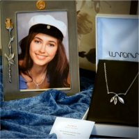 A silver necklace and earrings and a graduation photo frame